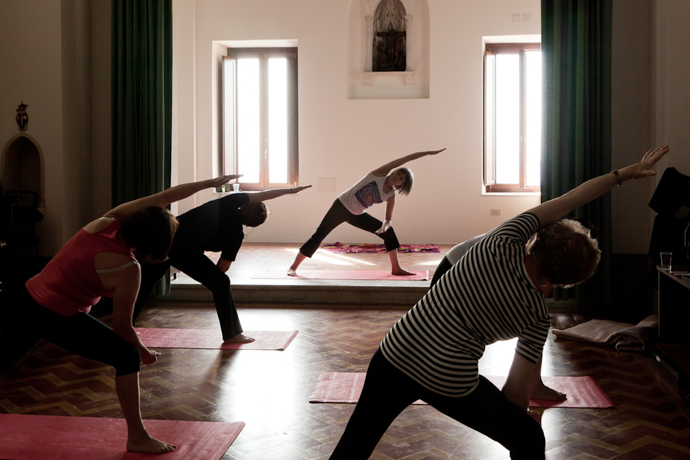 Rose and the class during an early morining indoor yoga session, Italy