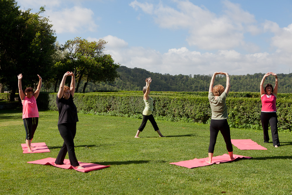 Rose and the class during an outdoor yoga session in the afternoon sunshine, Italy