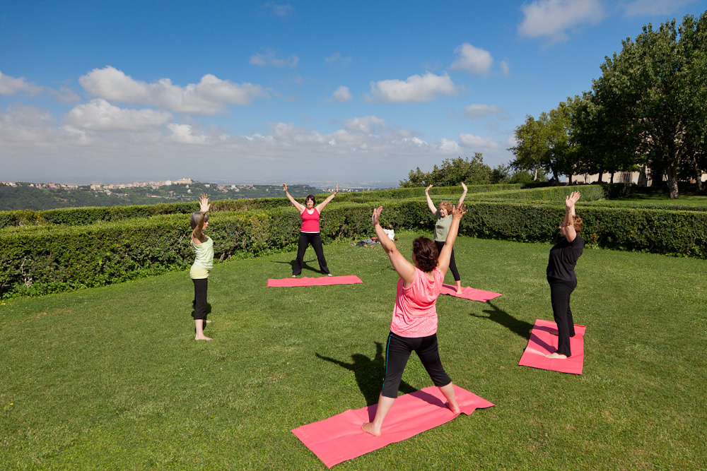 Rose and the class during an outdoor yoga session in the afternoon sunshine, Italy